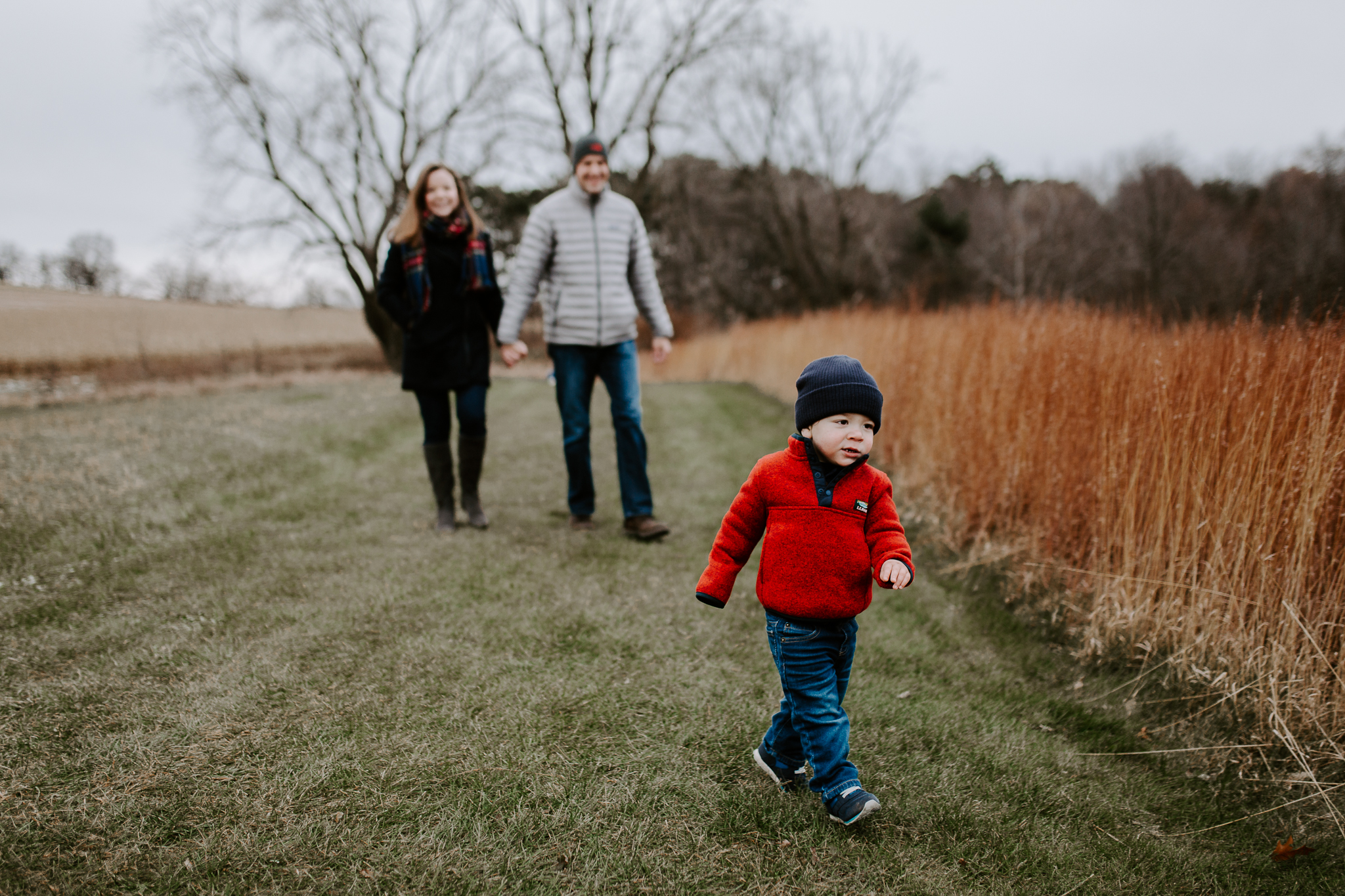 Young family lifestyle photo in a dried grass field.